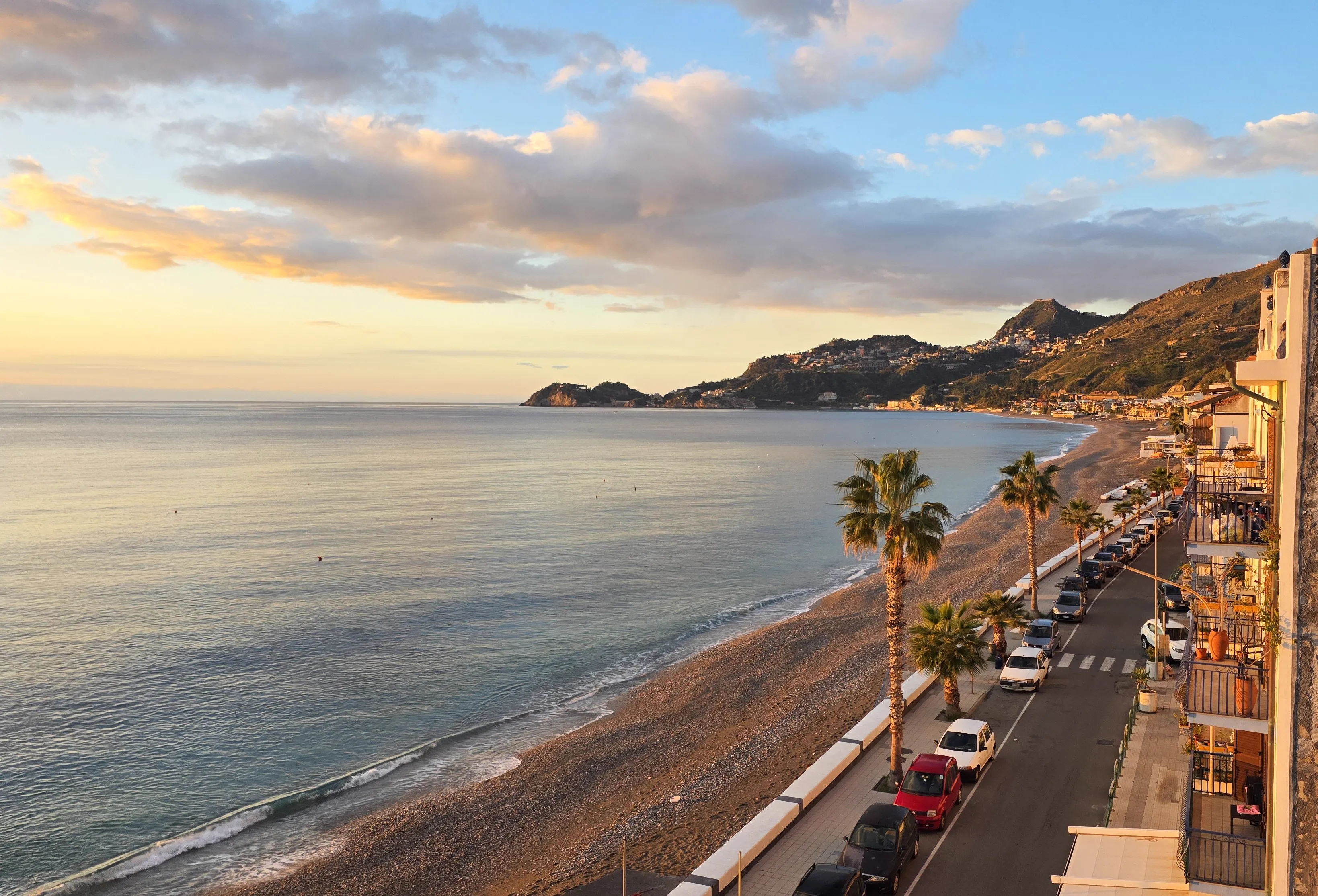 Wybrzeże Sycylii o zachodzie słońca - palmy i zatoka Taorminy